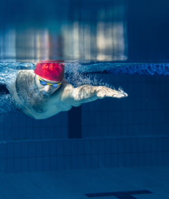 one male swimmer practicing and training at pool
