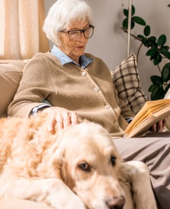 Senior readying with a dog