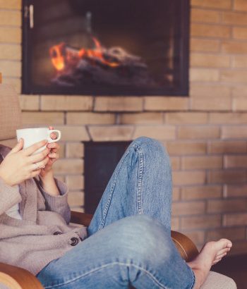 Women drinking tea next to fireplace